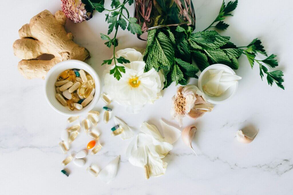 Frascos de medicamentos naturais ao lado de plantas medicinais, representando tratamentos naturais utilizados na medicina antroposófica.
