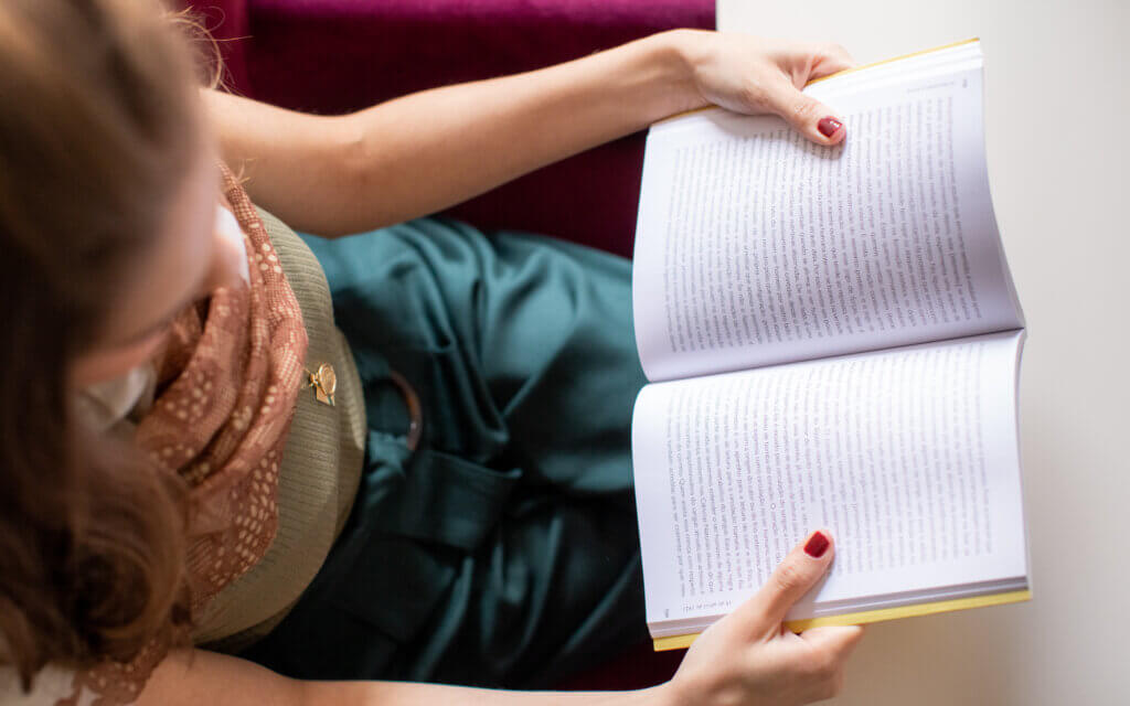 Mariana Azoubel lendo livro sobre medicina antroposófica, em momento de estudo e aprofundamento em práticas de saúde integrativa